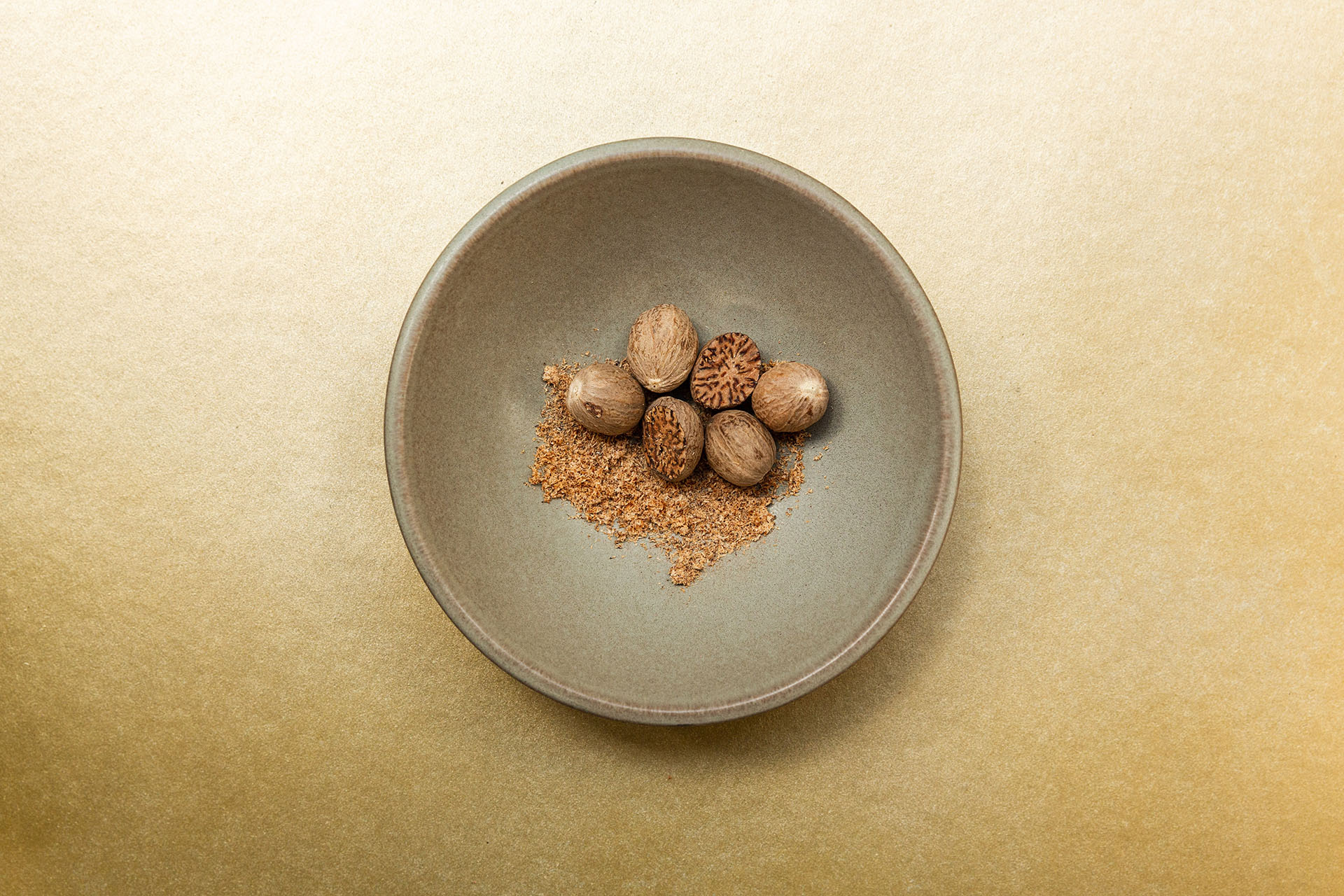 whole and ground nutmeg in a bowl