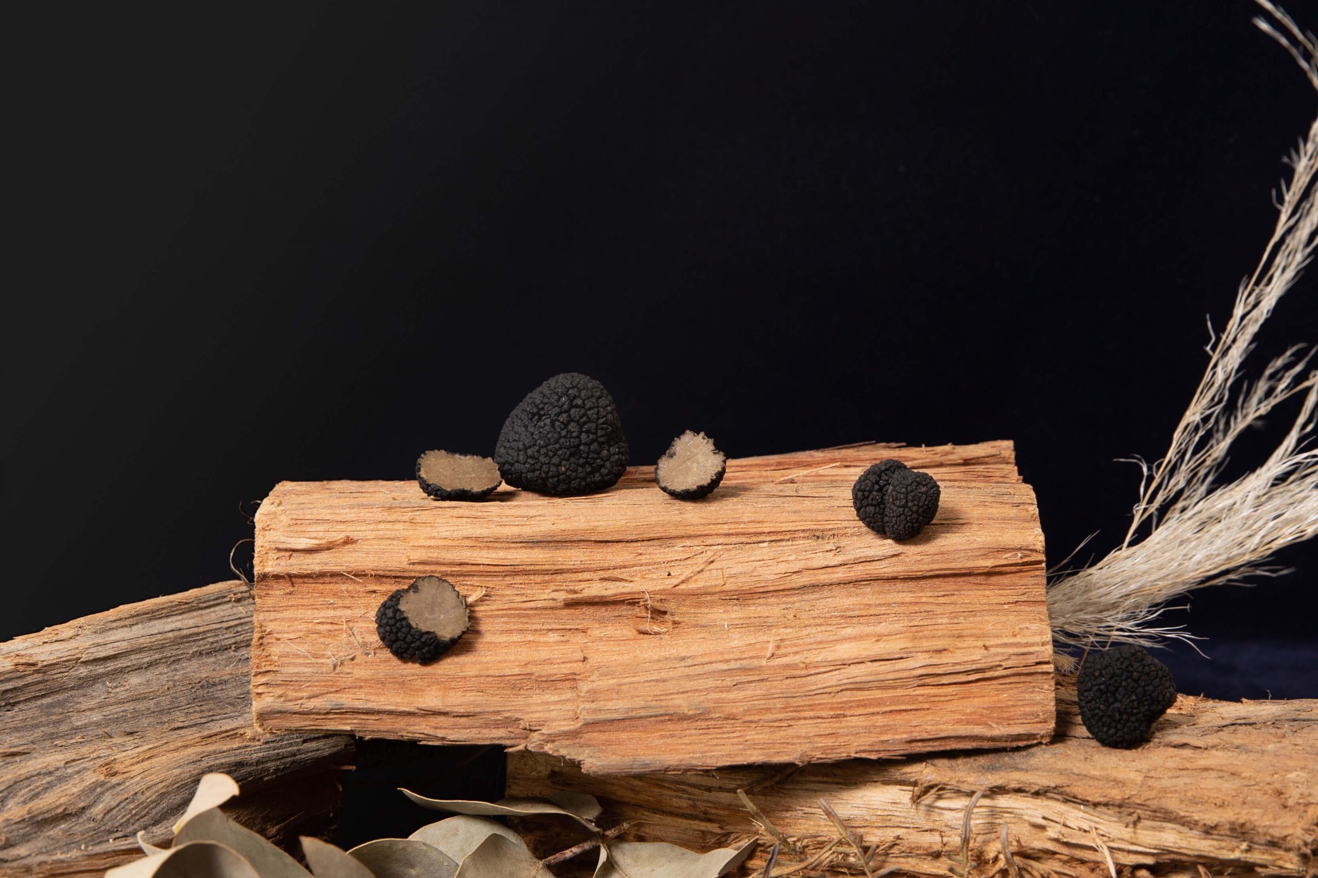 whole and cut truffles on wood